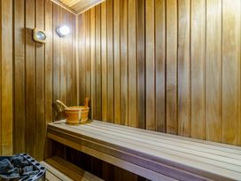 A sauna with wooden benches and a bucket at Muirloch Spa Plus (Pet) Dundee