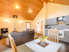 A living room with a sofa and kitchen counter at Muirloch Spa Plus (Pet) Dundee