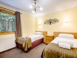 A bedroom with two beds and a tree wall decor at Barnard Lodge in Dundee