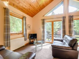 A living room with a sofa and television at Barnard Spa (Pet) Dundee