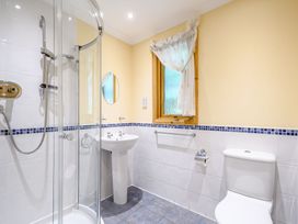 A bathroom with a shower, sink, and toilet at Rainbow Spa (Pet) Dundee