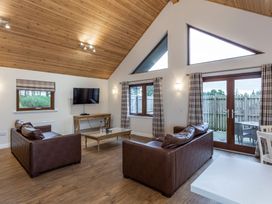 A living room with a sofa and television at Raeburn Premier Spa in Dundee