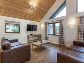 A living room with a TV and sofa at Raeburn Premier Spa in Dundee