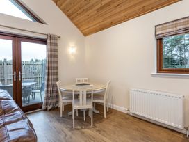 A dining room with a table and chairs at Raeburn Premier Spa (Pet) in Dundee