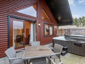An outdoor patio with a hot tub and a table at Raeburn Premier Spa (Pet) Dundee