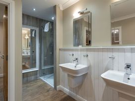 A bathroom with sinks and a shower at Raeburn Premier Spa (Pet) in Dundee
