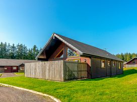 A house with a fence and trees at Rainbow Spa Plus Dundee