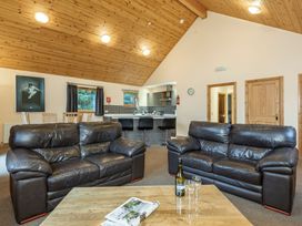 A living room with sofas and a kitchen area at Rainbow Spa Plus in Dundee