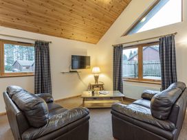 A living room with sofas and a television at Rainbow Spa Plus (Pet) in Dundee