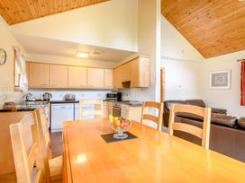 A kitchen with a dining table and chairs at Osprey Lodge in Dundee