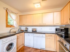 A kitchen with appliances including a washing machine and dishwasher at Osprey Lodge in Dundee