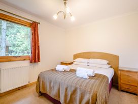 A bedroom with a bed and window at Osprey Lodge in Dundee
