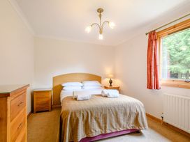 A bedroom with a bed and nightstand at Osprey Lodge in Dundee