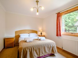 A bedroom with a bed and nightstand at Osprey Lodge in Dundee