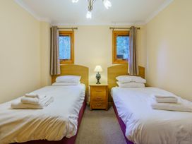 A bedroom with twin beds and a bedside table at Osprey Spa (Pet) in Dundee