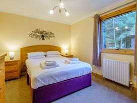 A bedroom with a bed and bedside tables at Osprey Lodge (Pet) Dundee
