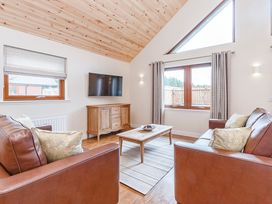 A living room with a sofa, table, and television at Galbraith Premier Spa (Pet) in Dundee