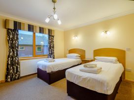 A bedroom with two single beds at Osprey Spa Plus (Pet) in Dundee