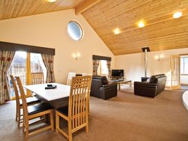 A living room with a dining area and seating at Osprey Spa Plus (Pet) in Dundee