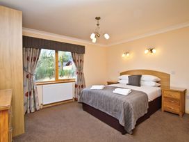 A bedroom with a bed and window at Osprey Spa Plus (Pet) in Dundee
