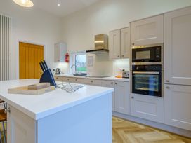 A kitchen with a sink, ovens, and kitchen island at Lochside Premier Spa in Dundee