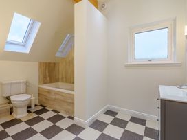 A bathroom with a bathtub, toilet, and sink at Lochside Premier Spa in Dundee