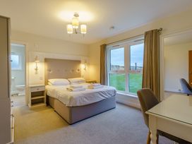 A bedroom with a bed and desk at Lochside Premier Spa (Pet) in Dundee