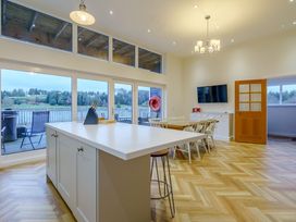 A kitchen with a dining table and large windows at Lochside Premier Spa (Pet) in Dundee