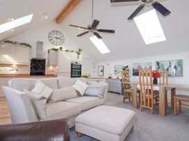 A living room with a sofa, dining table and kitchen cabinets at 33 Fordh Tobmen in St. Agnes