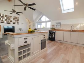 A kitchen with a washing machine and television at 33 Fordh Tobmen in St. Agnes