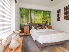 A bedroom with a bed and nature-themed wall at 33 Fordh Tobmen St. Agnes