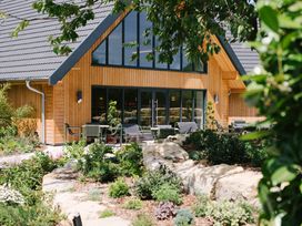 A building with large windows and chairs in a garden at Belfry in Waltham