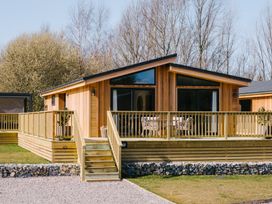 A cabin with a wooden deck and outdoor seating at Moonlight Spa Luxury in Waltham