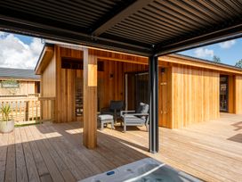 An outdoor area with a hot tub and chairs at Moonlight Spa Luxury in Waltham