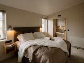 A bedroom with a bed and a bathroom door at Luxury One Bedroom Retreat in Waltham