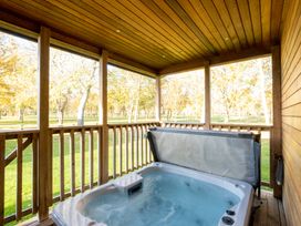 An outdoor area with a hot tub on a wooden deck at Wentworth in Waltham