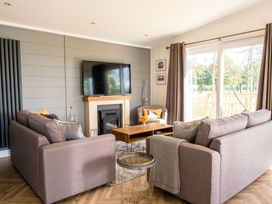 A living room with a television and sofa at Goldfinch in Waltham