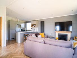 A living room with a television and kitchen area in Goldfinch Waltham