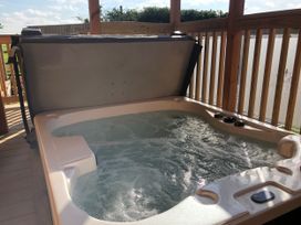 A hot tub on a deck with water jets at Goldfinch in Waltham