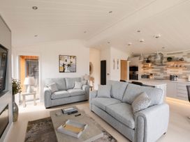 A living room with a sofa and a kitchen area at The Luxury Hideaway in Waltham