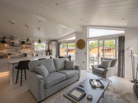 A living room with a sofa and kitchen area at The Luxury Hideaway in Waltham