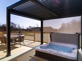 An outdoor deck with a hot tub and seating at The Luxury Hideaway in Waltham
