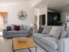 A living room with grey sofas and a coffee table at The Luxury Hideaway in Waltham