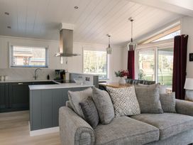 A living room with a sofa and kitchen counter at The Luxury Hideaway in Waltham