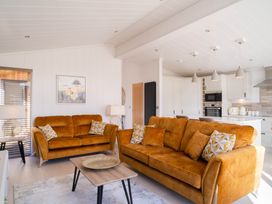 A living room with orange sofas and a coffee table at Luxurious Serenity in Waltham