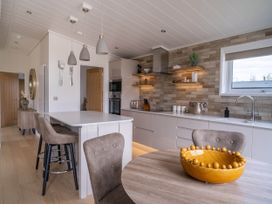 A kitchen with a dining table and modern appliances at The Luxury Escape in Waltham