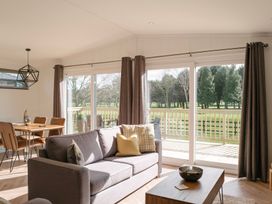 A living room with a sofa and dining area at Dovecote in Waltham