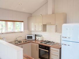A kitchen with a sink, microwave, toaster and refrigerator at The Henley in Waltham
