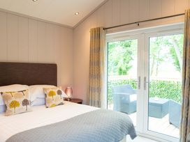 A bedroom with a bed and window leading to a deck at The Henley in Waltham