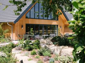 A wooden building with patio seating in a garden at The Henley in Waltham